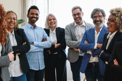 Multiracial business people of different ages looking at camera inside bank office - Focus on indian man face