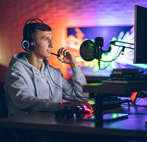 Cybersport gamer having live stream game in room with neon lighting in background for article on esports as a CTE pathway