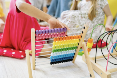 Child's hand playing with beads on abacus for education story on math anxiety