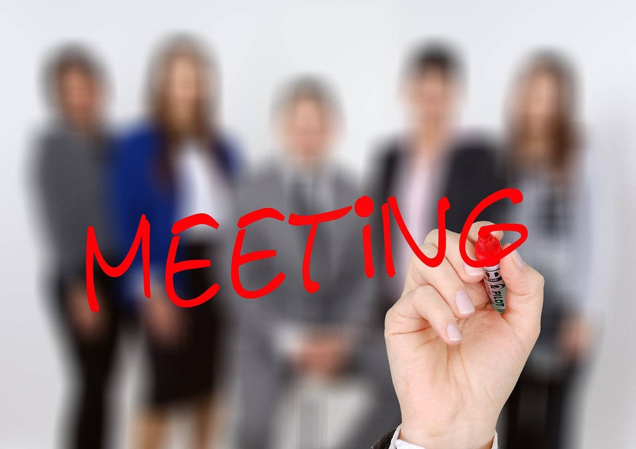 A group of people with the word meeting over the image.