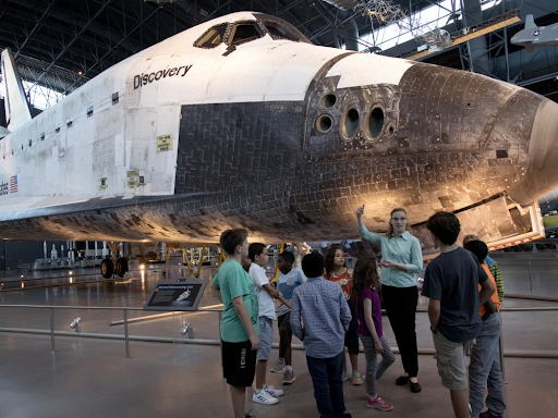 Astronomy educator Shauna Edson leads students through the Smithsonian’s National Air and Space Museum. The Space Shuttle Discovery behind them is currently on display at the Stephen F. Udvar-Hazy Center in Chantilly, Va. In 2012, NASA transferred Discovery to the Smithsonian after a delivery flight over the nation's capital.