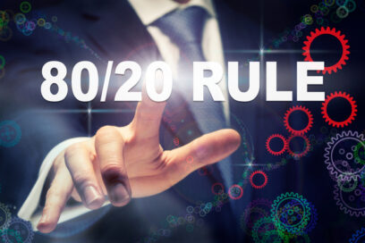 A businessman pressing a 80/20 Rule business concept on a graphical display of cogs for article on education leadership 80/20 rule